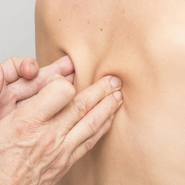 Hands working on a patient's lower back