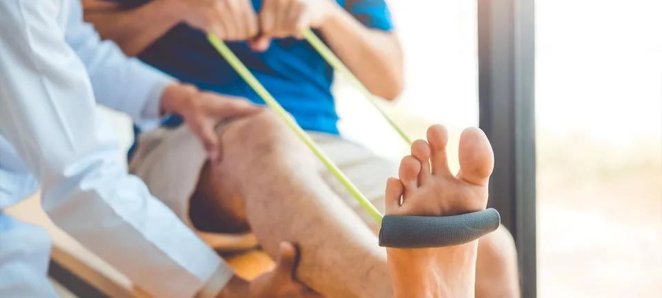 Practitioner guiding a patient through a resistance-band leg exercise